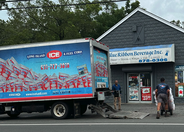 workers unloading a truck infront of a store