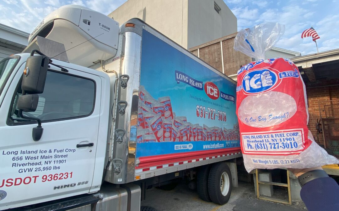 Professionally made bagged ice being held up in front of an ice truck on Long Island