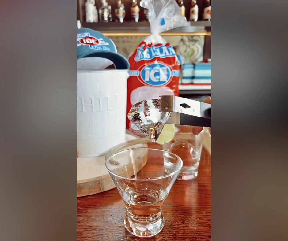 A photo of custom diamond-shaped gourmet ice in a beautiful glass on a counter