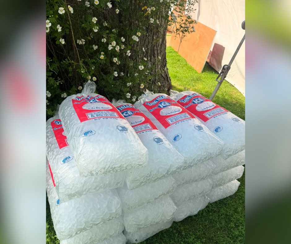 Bags of pre-packaged ice on a lush green lawn.